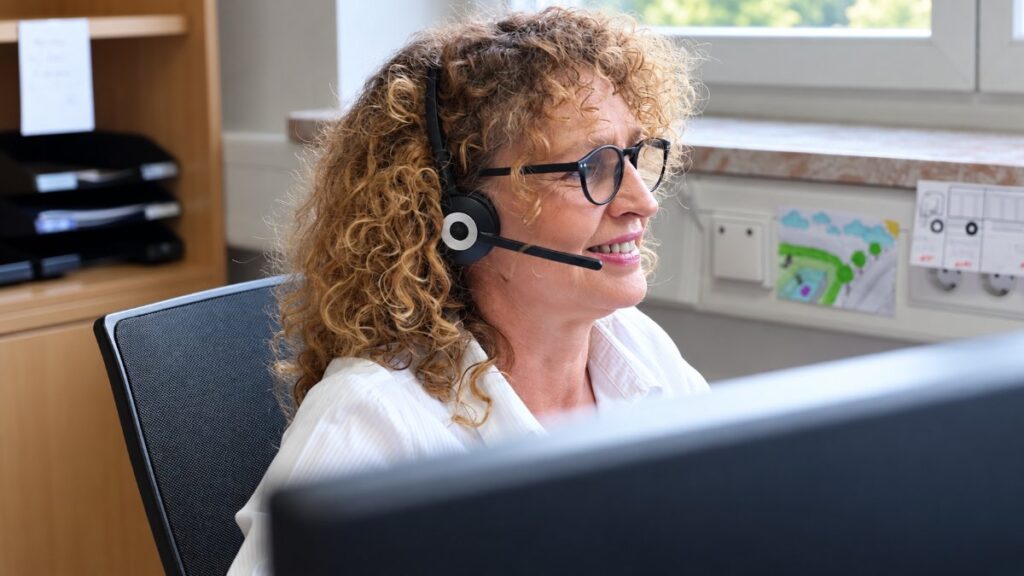 Mitarbeiterin mit Headset am Arbeitsplatz